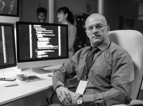 Security-Analyst prüft Code auf mehreren Monitoren